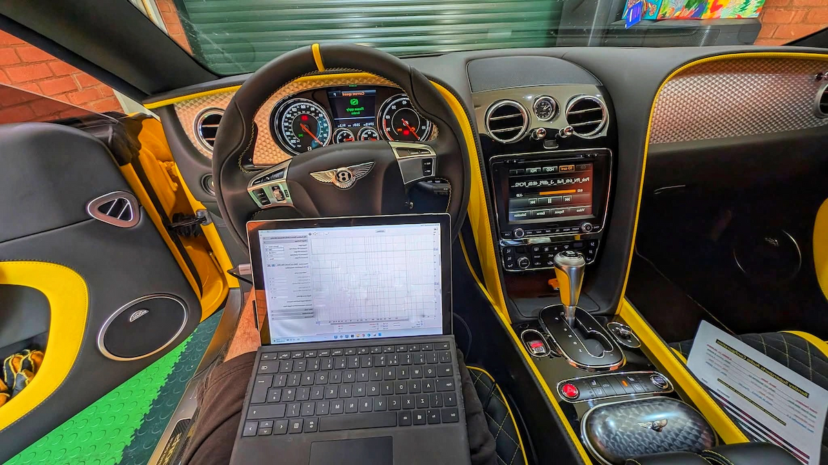 Specialized diagnostic laptop setup inside a luxury Bentley cockpit during a pre-purchase inspection